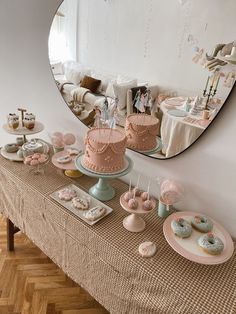 a table topped with cakes and donuts next to a mirror