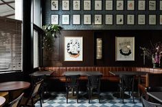 a restaurant with black and white checkered flooring, wooden booths and framed pictures on the wall