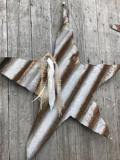 a metal star hanging on the side of a wooden wall