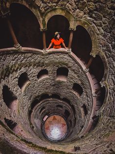 a woman sitting on top of a stone structure