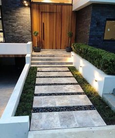 a modern house with stone steps leading up to the front door and side entrance area