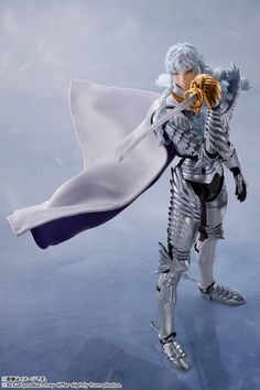 the action figure is dressed in armor and holding a golden object with one hand, while standing on ice