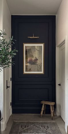 an entryway with a bench and painting on the wall above it, along with a potted plant