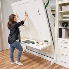 a woman standing in front of a white cabinet