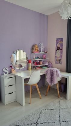 a white desk with two chairs and a mirror on the wall in a purple room