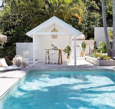 a pool with a gazebo and chairs next to it