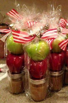 apples wrapped in cellophane with candy canes and bows are sitting on top of each other