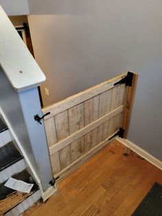 an unfinished room with wood flooring and wooden door on the side of the wall