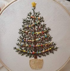 a hand embroidered christmas tree on a white hoop