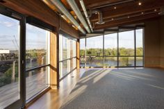 an empty room with large windows overlooking the river