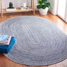 a blue rug on the floor next to a table with a potted plant in it