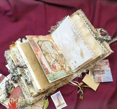 an old book is sitting on a purple cloth