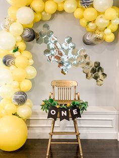 a chair sitting in front of a balloon arch