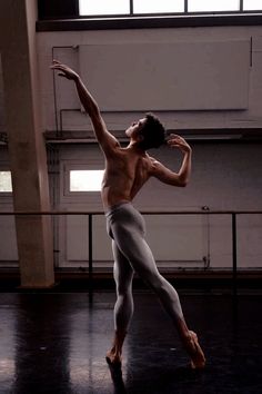 black and white photograph of a ballerina in the middle of an empty room with windows