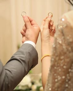 the bride and groom hold hands as they stand close to each other with their wedding rings on their fingers