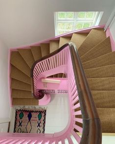 a pink spiral staircase in a house with carpet on the floor and rug on the wall