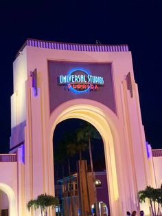 the entrance to universal studios is lit up at night