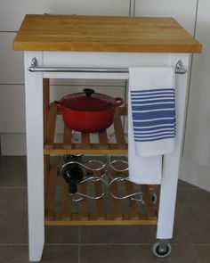 a kitchen cart with a pot and pan on it in front of a stove top