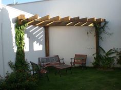 an outdoor area with chairs and a pergolated trellis on the outside wall