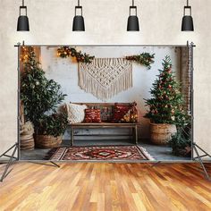 a room decorated for christmas with potted trees and decorations on the wall behind it