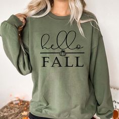 Welcome the cozy season in style with the Hello Fall Graphic Sweatshirt. Perfect for embracing all the warmth and charm of autumn, this sweatshirt is your go-to for everything from pumpkin picking to cozy nights by the fire. Crafted from ultra-soft, premium fabric, the Hello Fall Sweatshirt offers a comfortable fit that’s perfect for layering on those crisp fall days. The relaxed design ensures all-day comfort, making it ideal for any seasonal activity. The graphic features a warm greeting, "Hello Fall," in a stylish font that captures the spirit of the season. Simple yet chic, this design adds a touch of fall flair to your wardrobe, making it easy to pair with jeans, leggings, or your favorite boots. Constructed with high-quality materials, this sweatshirt is designed to maintain its soft Cozy Comfortable Fall Sweater, Everyday Fall Crew Neck Sweatshirt, Green Long Sleeve Sweatshirt For Fall, Cozy Fit Sweater For Everyday Fall Wear, Comfortable Relaxed Fit Sweater For Fall, Trendy Fall Sweatshirt With Relaxed Fit, Fall Loungewear Crew Neck Sweater, Trendy Relaxed Fit Sweatshirt For Fall, Comfortable Cotton Sweater For Fall