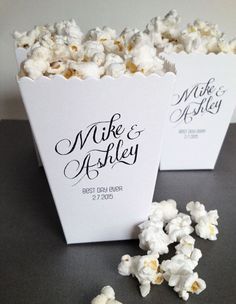 two white boxes filled with popcorn sitting on top of a table