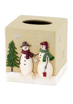 two snowmen standing next to each other in front of a tissue dispenser