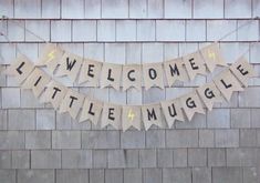 a welcome little muggle banner hanging on the side of a building