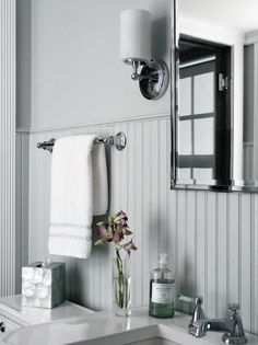 a white bathroom sink sitting under a mirror next to a wall mounted faucet