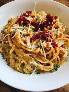 a white bowl filled with pasta and sauce