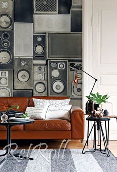 a living room with a couch, table and speakers on the wall