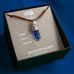 a necklace in a box with a star wars pendant on it's cord that is attached