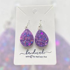 Each earring is handcrafted with care.  * Handcrafted with high-quality resin for durability and beauty. * Lightweight design for comfortable all-day wear. * Hypoallergenic for sensitive ears. * Each earring is unique and may be slightly different from what is pictured. No two earrings are completely alike. Material: * UV resin * Glitter * Hypoallergenic and nickel free Stainless Steel hardware Care: *To clean your earrings, use a damp cloth and wipe gently. *Remove the earrings before showering or swimming. *Avoid using chemicals, perfume, jewelry cleaners, or any aerosol products. Do not hesitate to send me a message if you have any questions. Please check my other listings at https://designsbymelissaa.etsy.com. Purple Dangle Teardrop Earrings Gift, Trendy Hypoallergenic Teardrop Drop Earrings, Handmade Resin Teardrop Earrings As Gift, Trendy Hypoallergenic Teardrop Earrings, Hypoallergenic Purple Dangle Teardrop Earrings, Trendy Hypoallergenic Dangle Teardrop Earrings, Trendy Nickel-free Teardrop Earrings, Trendy Teardrop Earrings As A Gift, Hypoallergenic Teardrop Pendant Earrings As Gift