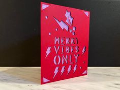 a red greeting card with the words merry vibes only written in silver on it