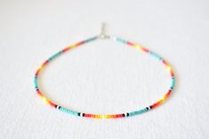 a multicolored beaded necklace on a white surface