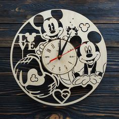 a wooden clock with mickey and minnie mouses on it