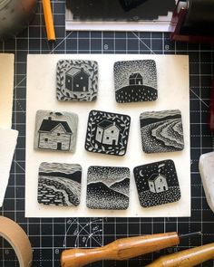 several small black and white plates sitting on top of a table next to some scissors