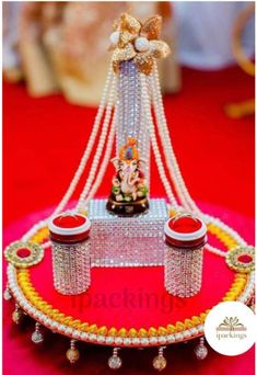 a table topped with two trays covered in pearls and other items on top of a red carpet