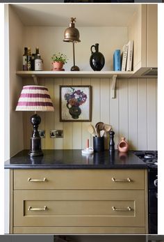 a kitchen with an oven, lamp and pictures on the wall above it's counter