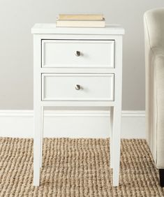 a white table with two drawers and a chair in front of it on a carpeted floor