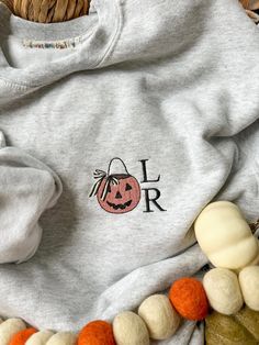 cozy up for fall in the sweetest embroidered sweatshirt featuring a classic pumpkin bucket with striped bow and your 2 initials of choice ::THE DETAILS:: - machine embroidered along left side chest - 2 character limit for monogram in font as shown - gildan sweatshirt & t-shirt, please review size chart in photos before ordering - machine washable x tumble dry low ::PLEASE NOTE:: - due to the customized nature of this item, refunds or returns cannot be accepted - please ask any questions before ordering CUSTOM ORDERS WELCOME! if you don't see what you're looking for - message me and we can work together to make your perfect sweatshirt! Fall Gift Sweatshirt With Embroidered Logo, Customizable Fall Sweatshirt For Gifts, Fall Custom Embroidery Sweatshirt Gift, Customizable Sweatshirt For Fall And Gifts, Custom Embroidery Sweatshirt As Fall Gift, Personalized Cotton Sweatshirt For Fall, Customizable Sweatshirt For Fall Gift, Personalized Fall Sweatshirt For Gift, Pumpkin Bucket