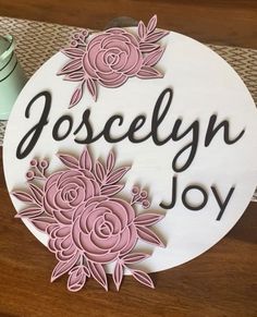 a wooden sign that says, joscelin joy with pink flowers on the front