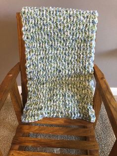 a wooden chair with a crocheted blanket on it