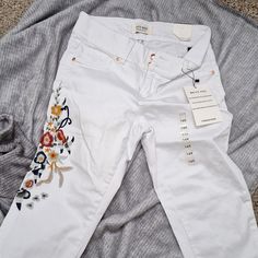 White Jeans With Colorful Embroidery On Right Leg Mid-rise Pants With Floral Embroidery For Spring, Spring Mid-rise Pants With Floral Embroidery, Mid-rise Cotton Pants With Floral Embroidery, Fitted Embroidered White Pants, White Embroidered Cotton Jeans, White Casual Pants With Floral Embroidery, Casual White Pants With Floral Embroidery, Fitted White Embroidered Pants, Spring Embroidered Cotton Jeans