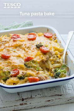 a casserole dish with broccoli, tomatoes and cheese in it on a table