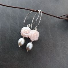 These gorgeous earrings consist of hand carved natural pale pink mother of pearl rose flower and silver tone dangle fresh water grey pearl. The earrings measure 45mm long (from top to end) Pale pink rose flower: 12mm pearl: 8mm x 6mm approximately All the metal parts are solid sterling silver. Please be aware that since the mother of pearl shell flowers and pearls are natural so no two pairs of earrings are identical but each flower and pearl are carefully handpicked to match each other for the