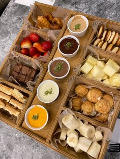 a box filled with lots of different types of food on top of a table next to utensils