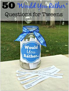 a jar filled with water sitting on top of a table next to some paper tags