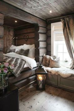 a bed with pillows and blankets in a room next to a window filled with windows