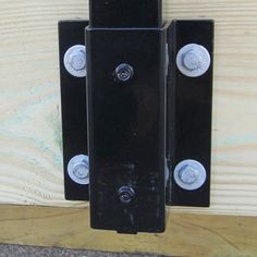 a black door hinge with three knobs attached to it's side wall